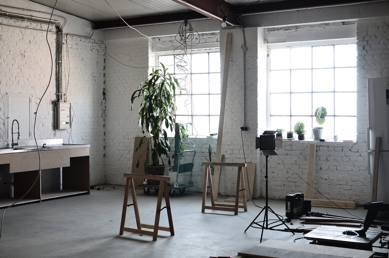 Interior of loft with brick wall with wires hanging on ceiling and tools for renovation  works